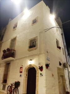 a large white building with a door and flowers on it at B&B Borgo San Martino in Monopoli