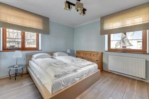 sypialnia z łóżkiem i 2 oknami w obiekcie Dom & House - Apartament Orłowskie Molo przy plaży z widokiem na morze w mieście Gdynia