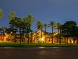 エルモシージョにあるHotel Boutique Villa Toscanaの夜のヤシの木が目の前に広がる建物