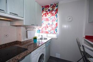 cocina con lavadora y ventana en Apartamento Excelentes vistas a la Ria, Wifi y Parking, en San Vicente de la Barquera