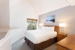 a white bedroom with a bed and a window at Lake Placid Lodge by Whiski Jack in Whistler +93 photos