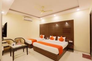 um quarto de hotel com duas camas e uma televisão em Hotel Citizen New Delhi em Nova Deli