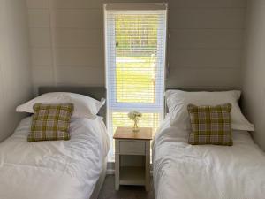 dwa łóżka siedzące obok okna w sypialni w obiekcie Hollicarrs - Newlands w mieście York