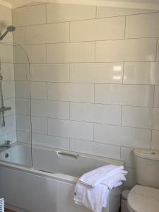 a white bathroom with a tub and a toilet at Hollicarrs - Newlands in York