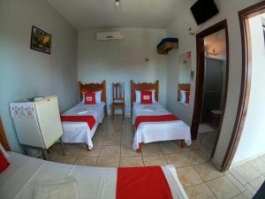 a room with three beds with red and white sheets at Lord Hotel in Várzea Grande