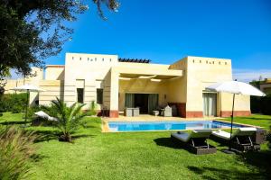 una villa con piscina y una casa en La Rose des Sables, en Marrakech