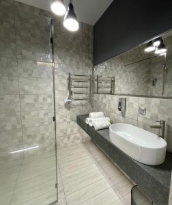 bagno con lavandino e doccia in vetro di Апарт-Готель у центрі Трускавця a Truskavec'