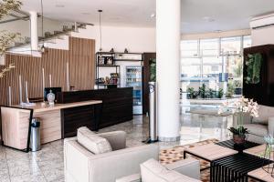 a living room with white furniture and large windows at Ferian Plaza Hotel in Itapira