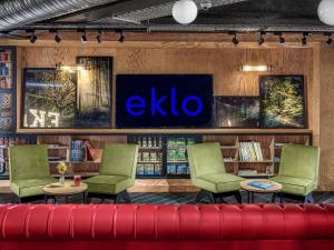 a library with green chairs and a blue sign on the wall at Eklo Marne La Vallée in Serris