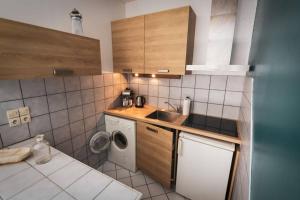 une petite cuisine avec un évier et une machine à laver dans l'établissement Marin Malouin,à 2 pas de la mer & d'intra muros, proche gare., à Saint-Malo 2 autres photos