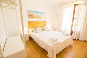 a white bedroom with a bed with towels on it at Beautiful private villa on the sea in Santanyi
