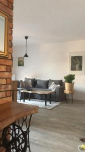 a living room with a couch and a table at Apartament Gościnne Sady in Malbork