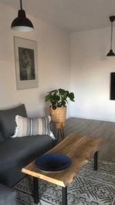 a living room with a couch and a wooden table at Apartament Gościnne Sady in Malbork