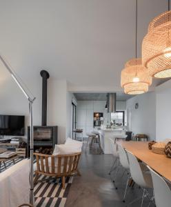 a living room and dining room with a table and chairs at Manos 114 in Comporta