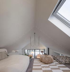a attic bedroom with a bed and a large window at Manos 114 in Comporta +35 photos