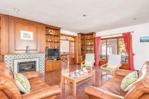 sala de estar con muebles de cuero y chimenea en Villa Gatzara by Villa Plus, en Cala Blanca