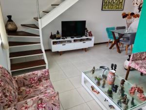 uma sala de estar com um sofá e uma televisão em Lindo Village na Praia de Stellamaris em Salvador