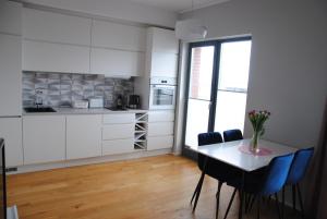 una cocina con mesa y sillas con un jarrón de flores en Rose Apartment en Pärnu