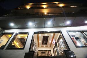 Hotel Citizen New Delhi في نيودلهي: مجموعة من النوافذ على مبنى في الليل