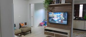 uma sala de estar com uma televisão de ecrã plano na parede em Casa Parque e Kartódromo em Penha