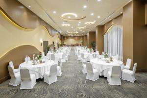 une salle de banquet avec des tables blanches et des chaises blanches dans l'établissement Millennium Makkah Al Naseem, à La Mecque