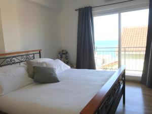 a bedroom with a large bed with a large window at Pink Inn in Podstrana