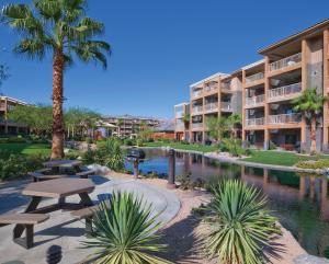 a resort with a pool and picnic tables and palm trees at WorldMark Indio in Indio
