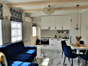 a living room with a couch and a table and a kitchen at GOLDEN QUEEN apartments in Juodkrantė