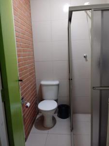 a small bathroom with a toilet and a shower at Hotel Veritas in Guarapuava