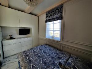 a bedroom with a bed and a window at GOLDEN QUEEN apartments in Juodkrantė