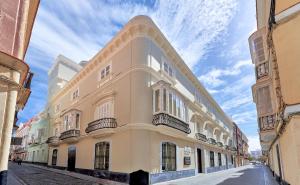 加的斯的住宿－Tandem Palacio Veedor de Galeras Suites，白色的建筑,在街上设有阳台