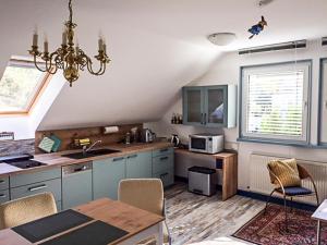 eine Küche mit einem Kronleuchter und einem Tisch im Zimmer in der Unterkunft Ferienwohnung Sonnengelb in Schwielowsee