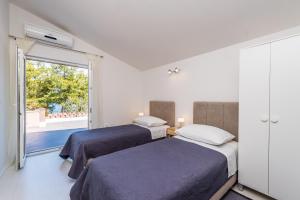 two beds in a room with a window at Apartment Anita in Savar