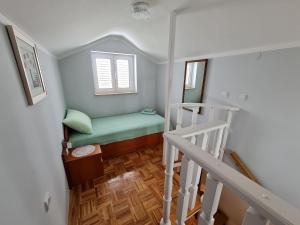 a small room with a green bed and a staircase at Apartments NEF in Pinezici