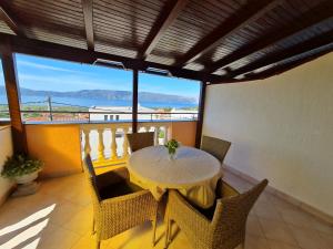 a dining room with a table and chairs on a balcony at Apartments NEF in Pinezici