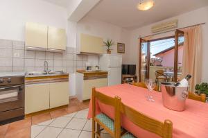 a kitchen with a table with a bottle of wine on it at Apartments Villa Estella in Srima