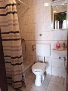 uma casa de banho com um WC, uma banheira e um lavatório. em Apartment Miho em Trsteno