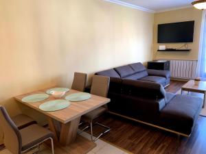 a living room with a table and a couch at Lakeside Luxury Apartment in Zamárdi