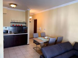 ザマールディにあるLakeside Luxury Apartmentのリビングルーム(ソファ、テーブル付)、キッチンが備わります。