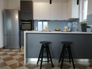 a kitchen with a counter with two bar stools at Apartments Jelka in Postira