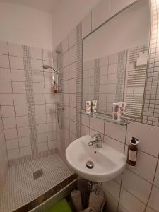 a white bathroom with a sink and a shower at Apartma Viktorija in Portorož