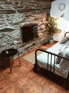 a living room with a stone fireplace and a couch at Casa do Douro in Alijó