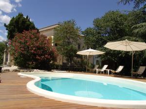 una piscina con sombrilla, sillas y mesas en Villa Pardi, en Manoppello
