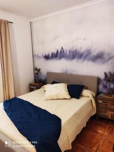 a bedroom with a bed with a painting on the wall at Apartamento junto al mar in Les Cases d'Alcanar
