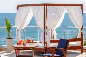 Un dormitorio con una cama y sillas y el océano. en Silver beach Studio Byala, en Byala