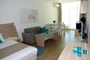 una habitación con una cama y un sofá y una mesa en Silver beach Studio Byala, en Byala