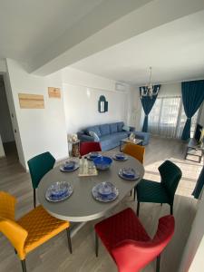 a dining room and living room with a table and chairs at Seafront Mamaia - Casa Del Mar Residence in Mamaia