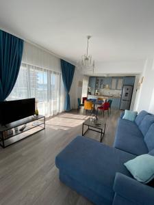 a living room with a blue couch and a table at Seafront Mamaia - Casa Del Mar Residence in Mamaia