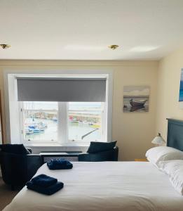 a bedroom with a bed and a large window at The Boathouse in Anstruther