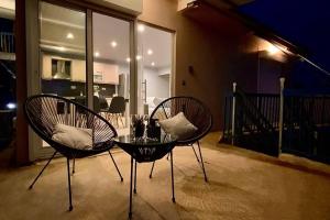 dwa krzesła i szklany stół na balkonie w obiekcie Ι Love Home Gold w Kalamácie